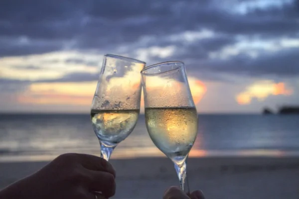 toast with 2 glasses of champagne on the beach