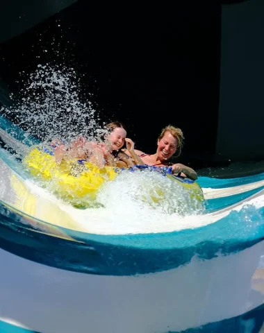 Two young people on a slide in a water park